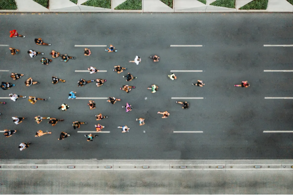 Aerial view of a large pack of runners moving down a wide, paved street