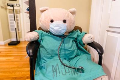 a teddy bear wearing scrubs and a stethoscope