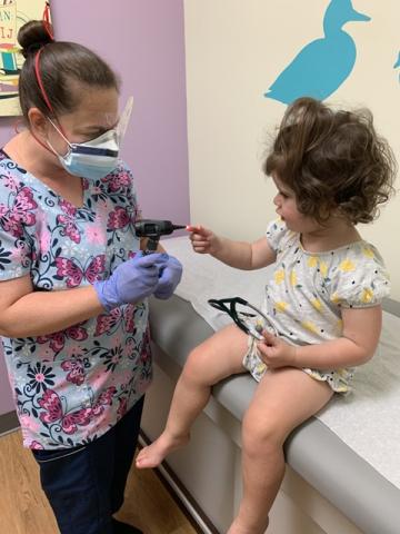 Clinician examines young girl