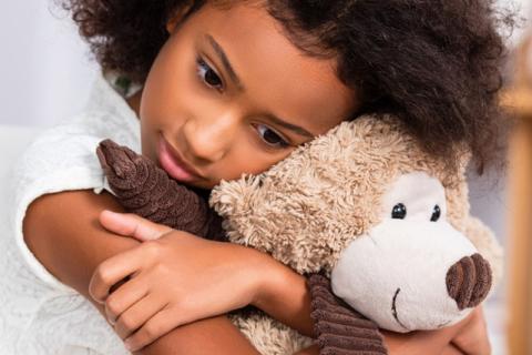 Concerned girl holds stuffed animal