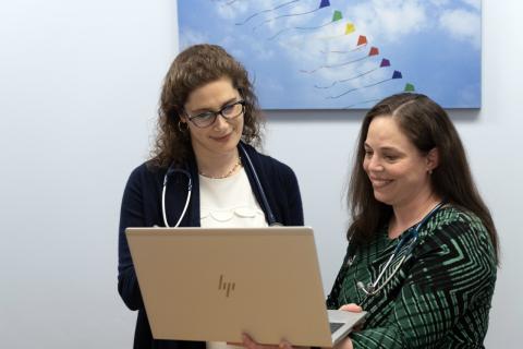Clinicians consult in front of laptop