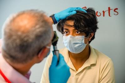 Clinician examines boy's eyes