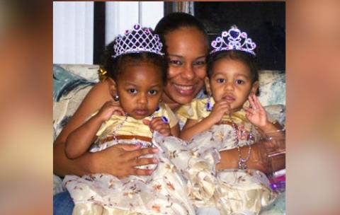 Woman hugs two girls who are wearing crowns on their head