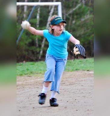 Girl with softball glove prepares to throw ball