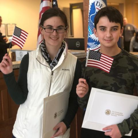 Teen girl and teen boy hold small American flags