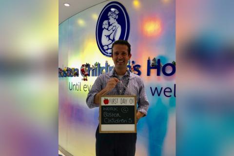 Matt holds a sign that says "First Day of Work at Boston Children's Hospital."