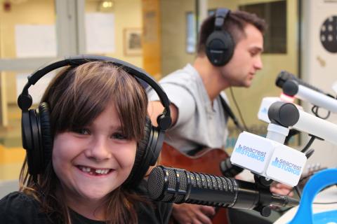 Girl smiles while behind microphone