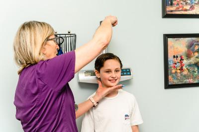 nurse taking a boy's height