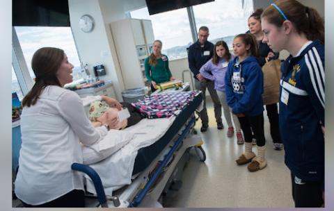 A clinician takes patients through an operating room.