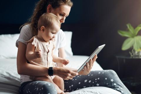 a mom and baby looking at a tablet