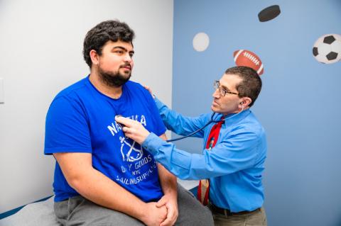 a teenage patient getting his heart listened to