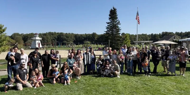 Patients and their families posing for a photo on a grass field