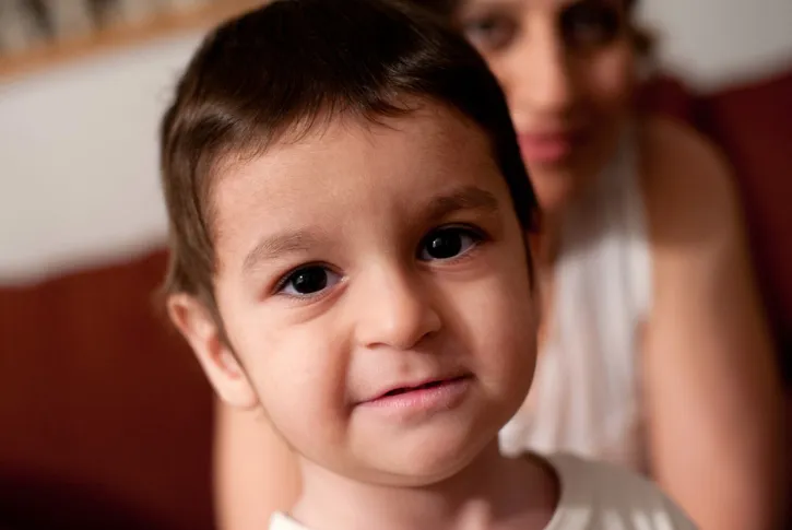 Boy in portrait, with mom in background