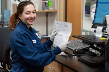 Lab technician in gloves holding a piece of paper