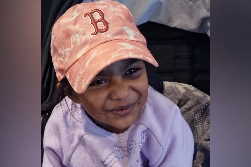 A close-up photo of four-year-old Kyleigh Kista wears a peach Red Sox cap and offers a slight smile.