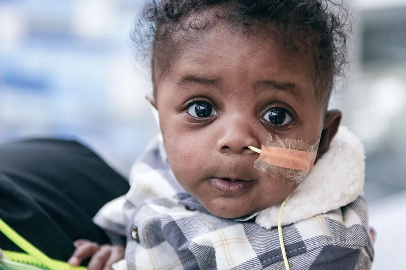 Toddler with brown eyes stares directly into camera