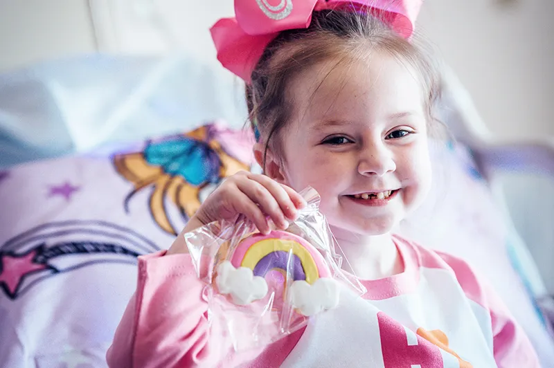 Girl wearing all pink with front teeth missing poses for camera