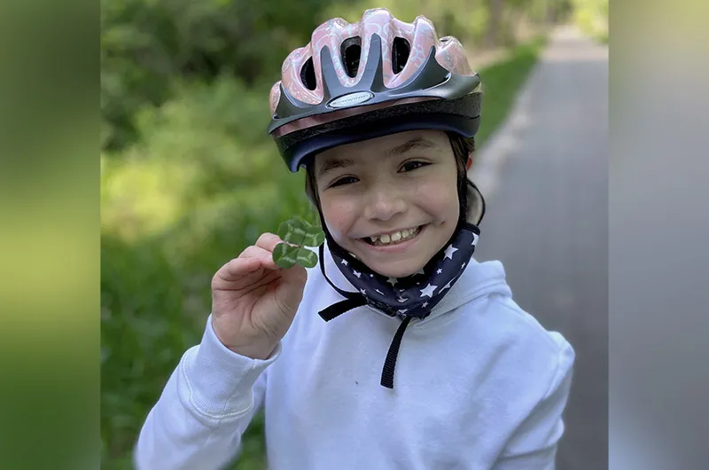 Girl wearing bicycle helmet while standing on bike path