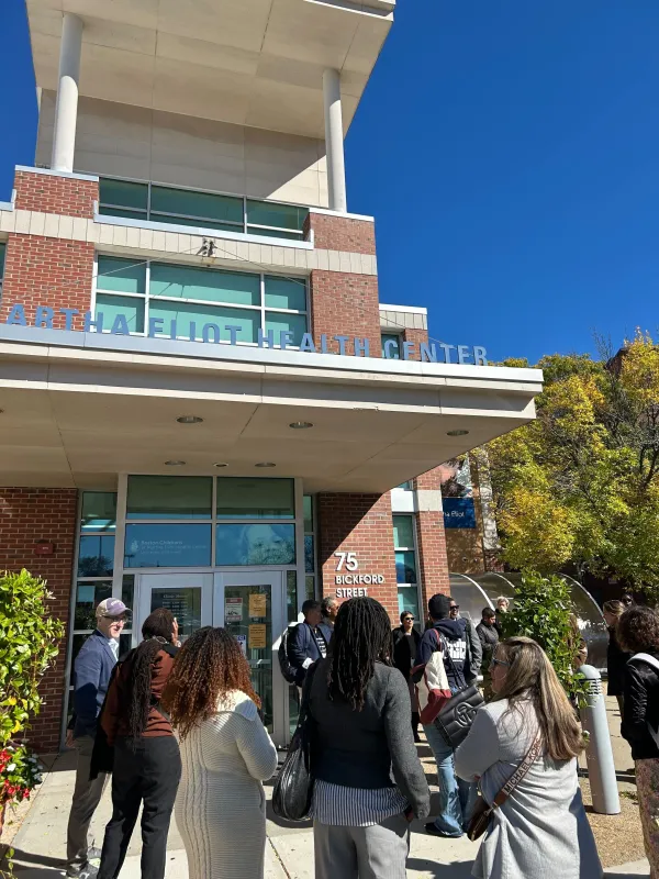 Crowd gathers in a circle at entrance to Boston Children's at Martha Eliot Health Center