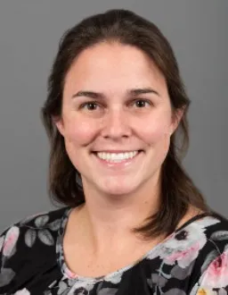 Headshot of Katie Livingston, a brunette woman wearing a floral patterned shirt smiles for her photo.