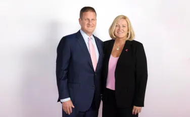 Man wearing suit and tie and woman wearing business suit pose for portrait