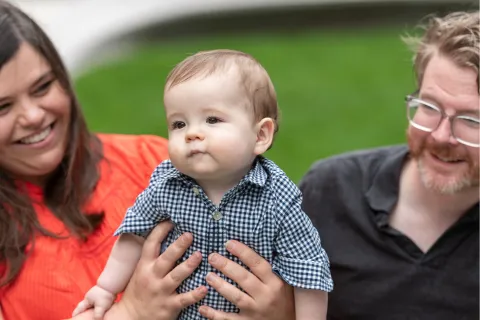 Mom and dad hold up toddler son
