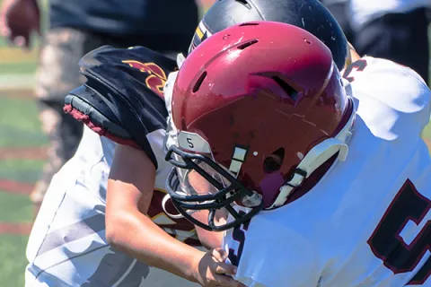 Opposing players run into each other on football field