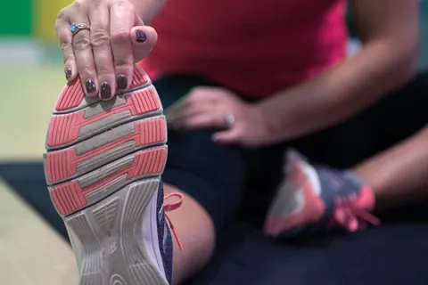 Female athlete does stretches with right leg
