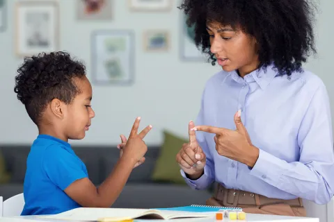 Young boy and woman use fingers to count