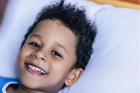 Young boy lays on pillow