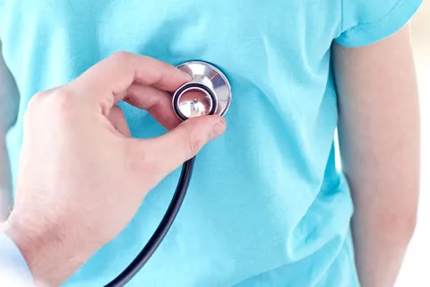 Clinician holds stethoscope against patient's upper back